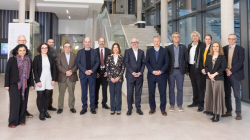 Group photo of people standing in a row, facing the camera, inside the main entrance of the EMBL Imaging Centre.